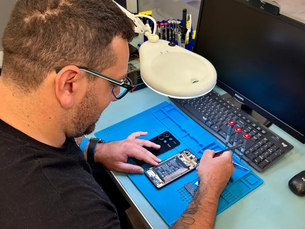 Técnico reparando pantalla de móvil en taller Quirobit Terrassa